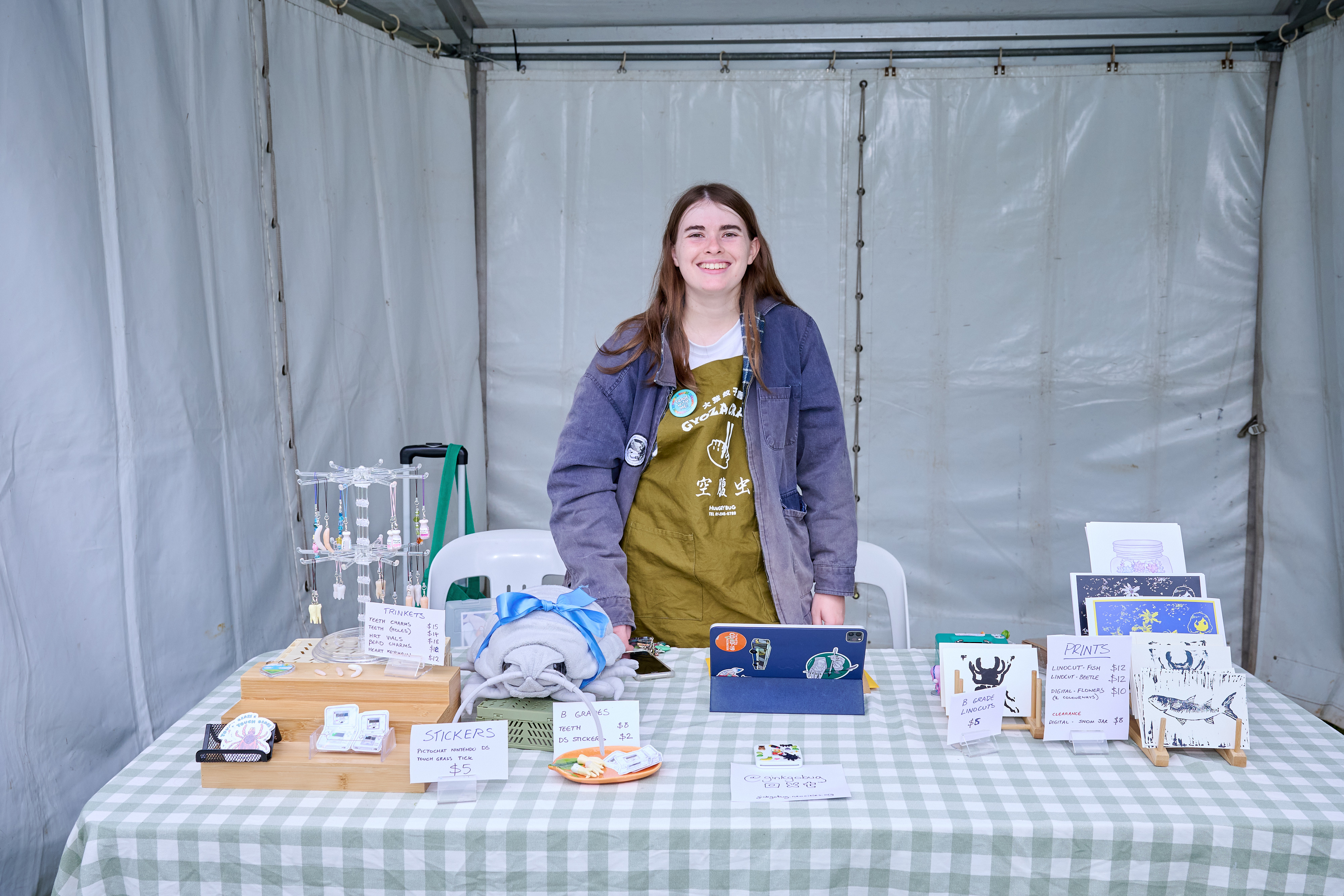 A photo of the artist at their booth at Queerfest 2025.